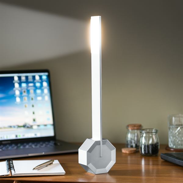 Gingko Octagon one desk lamp in Silver Aluminium on a desk upright turned on