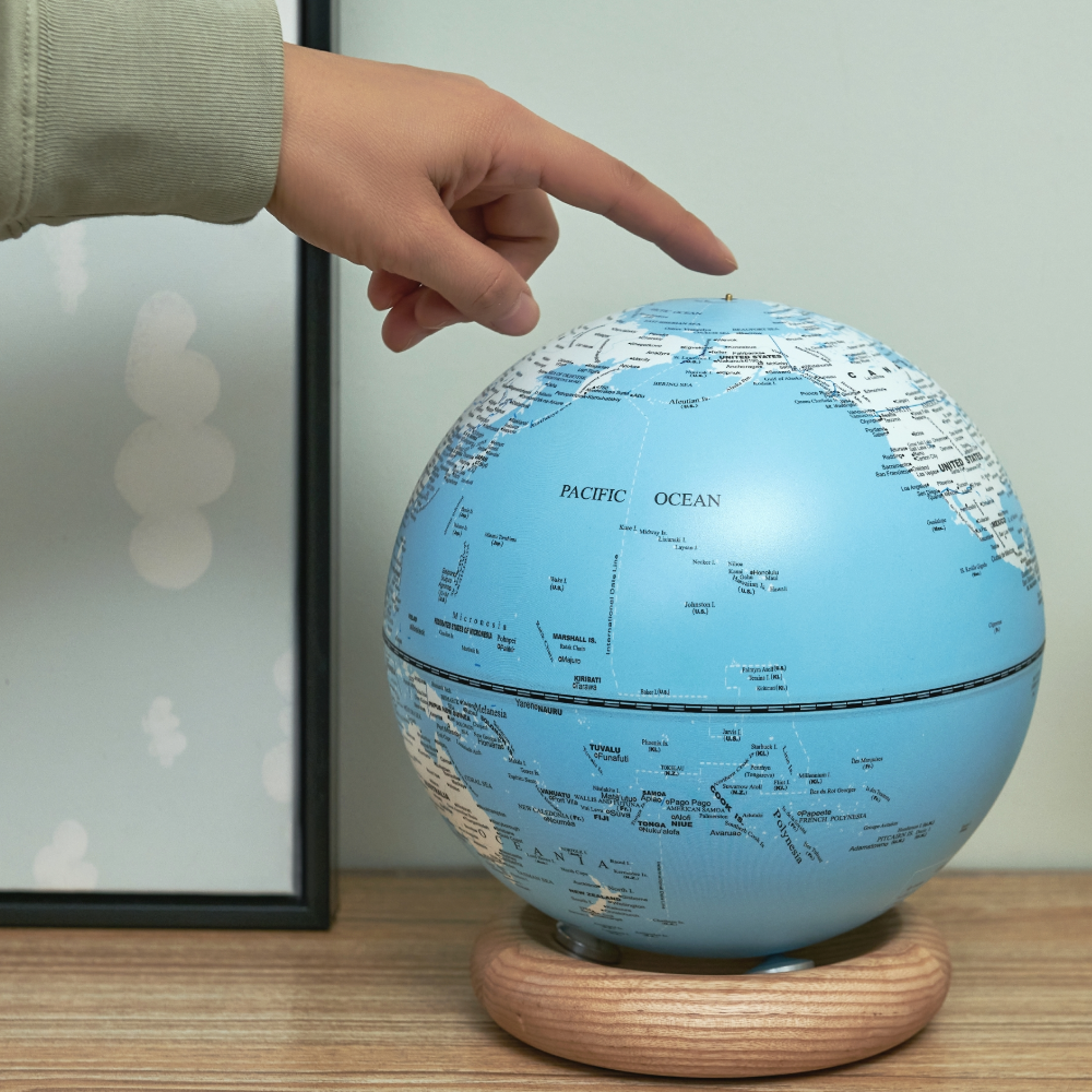 Gingko Large Light Sky Blue Atlas Globe showing a hand for proportion